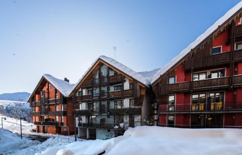 un grand bâtiment dans la neige dans l'établissement Borgo Stalle Residence, à Prato Nevoso