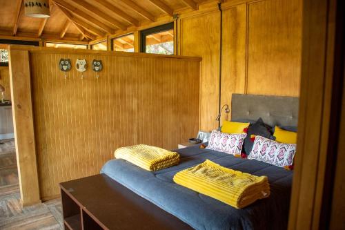 1 dormitorio con 2 camas con almohadas amarillas en Cabaña Chucao, en Conguillio