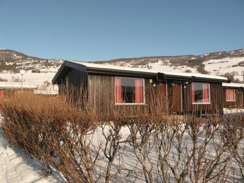 a small house with red windows in the snow at Dovre Motell in Dovre
