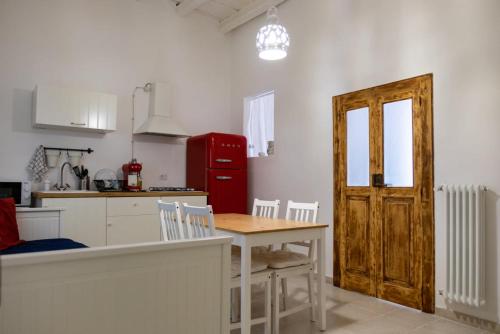 een keuken met een tafel en stoelen en een rode koelkast bij Amalfi Pool Suite - Puglia Mia Apartments in Monopoli