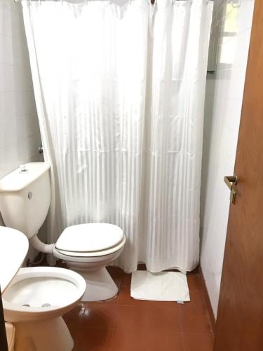 a bathroom with a toilet and a white shower curtain at Hotel Europa in Ostende
