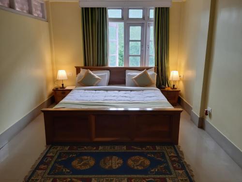 una camera con un grande letto e una finestra di Pemaling Lords Inn Dirang a Dirang Dzong