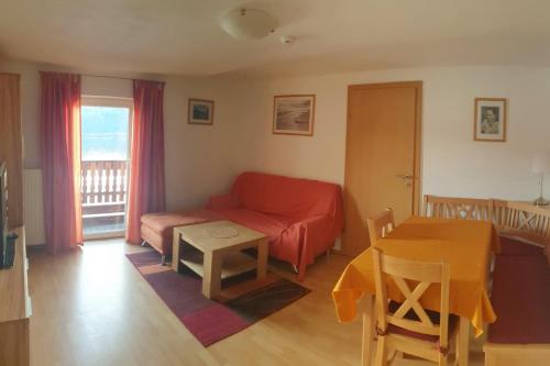sala de estar con sofá rojo y mesa en Haus am Hang en Innerschwand