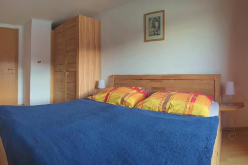 a bedroom with a bed with a blue blanket at Haus am Hang in Innerschwand am Mondsee