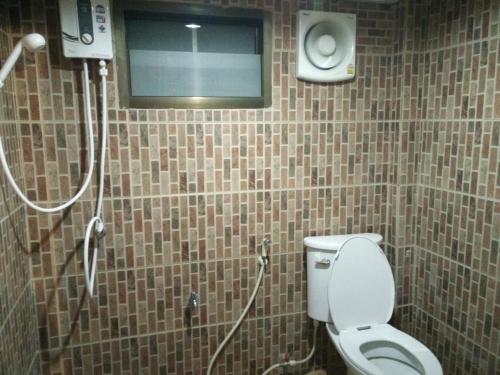 a bathroom with a shower with a toilet and a window at ต้งโฮมหละปูน ณ ตูบคำ in Lamphun