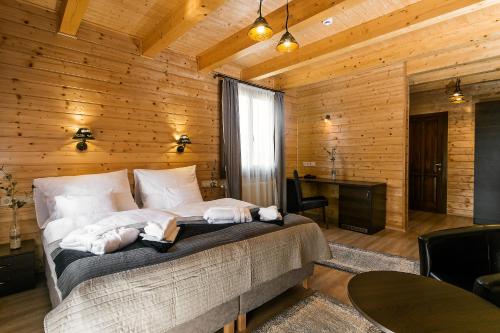 1 dormitorio con 1 cama en una habitación con paredes de madera en Barrico Thermal Hotel en Demjén