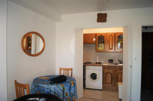 a room with a kitchen with a table and a washing machine at studio 150 m de la mer in Six-Fours-les-Plages