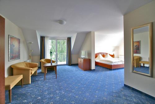 ein Hotelzimmer mit einem Bett und einem Spiegel in der Unterkunft Bodenseehotel Immengarten in Bodman-Ludwigshafen