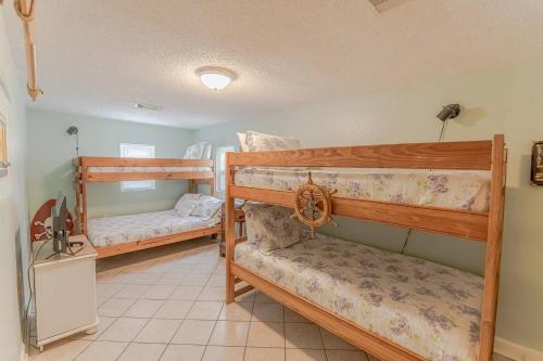 a bedroom with two bunk beds in a room at CasaSeaSpell Galveston in Galveston