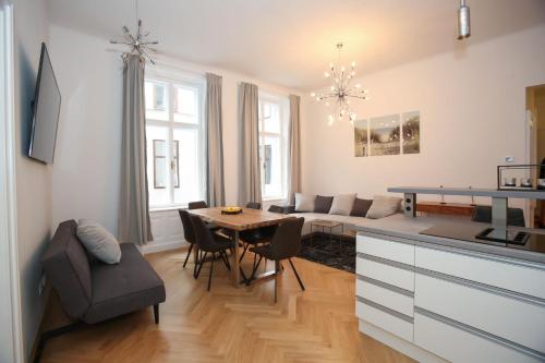 a kitchen and living room with a table and a couch at Luxusapartment Altes Rathhaus in Vienna