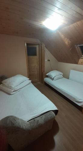 ein Schlafzimmer mit zwei Betten und einer Deckenleuchte in der Unterkunft Cabana Larisa in Cavnic