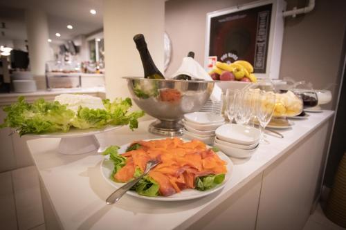 a counter with plates of food and a bowl of salad at Ferretti Beach Hotel in Rimini