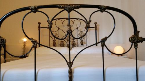 an iron bed with white sheets and a black frame at Suite Florencia in Santa Clara