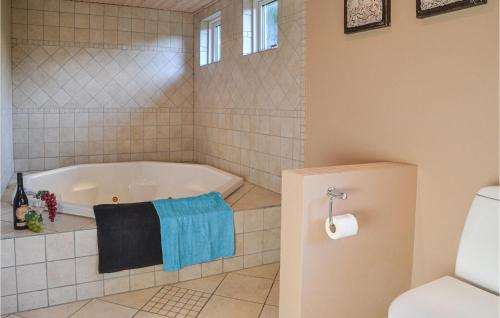 a bathroom with a tub and a toilet at Pet Friendly Home In Ansager With Sauna in Ansager