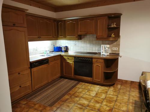 a kitchen with wooden cabinets and a stove top oven at Ferienwohnung Seidl Top 1 in Rauris