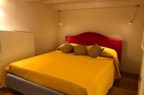ein Schlafzimmer mit einem gelben Bett mit zwei Kissen in der Unterkunft La casina in Burlamacchi in Mailand