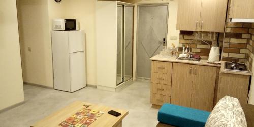 a kitchen with a refrigerator and a table in it at Lily`s Loft in Yerevan