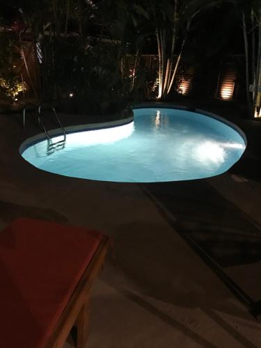 a large swimming pool at night with lights at Anam Apartments in Santa Teresa Beach
