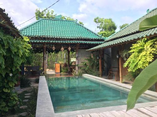 a house with a swimming pool next to a building at Watukarung Ristu Homestay in Kalak