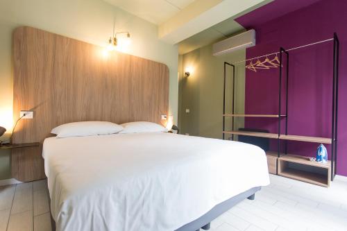a bedroom with a large white bed and purple walls at Unico Studios in Milan