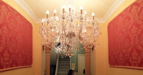 a chandelier in a hallway with red walls at Apartamentos Marques De La Merced in Málaga
