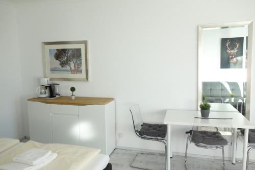 Cette chambre blanche dispose d'une table et de chaises blanches. dans l'établissement Appartement Anne, à Hahnenklee