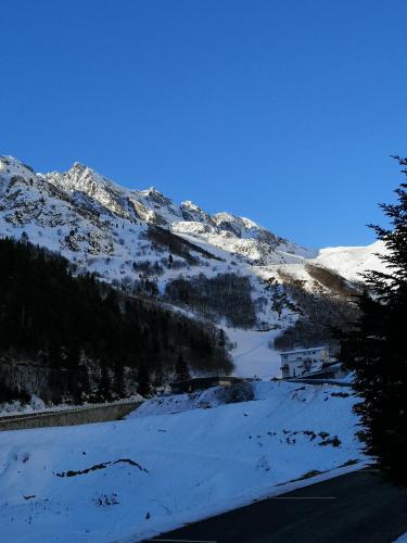a snow covered mountain with a road in the foreground at La Sapinière St Lary Soulan in Saint-Lary-Soulan