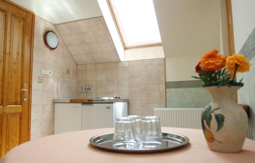 a kitchen with a table with glasses and a vase with flowers at Élet es Energia Egészségjavító Szalon in Nagykőrös