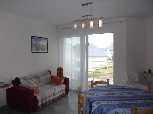 a living room with a couch and a bed and a window at villa marine 2 in Jullouville-les-Pins
