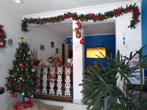 a christmas room with a christmas tree and decorations at Hostel365 in Angra dos Reis