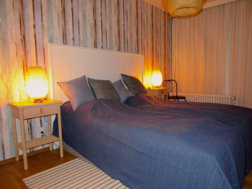 Ferienwohnung Seepferdchen في تيميندورفير ستراند: غرفة نوم بسرير ازرق كبير ومصباحين