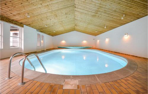 a large indoor swimming pool with a wooden ceiling at Lystrup Gamle Skole in Nørager