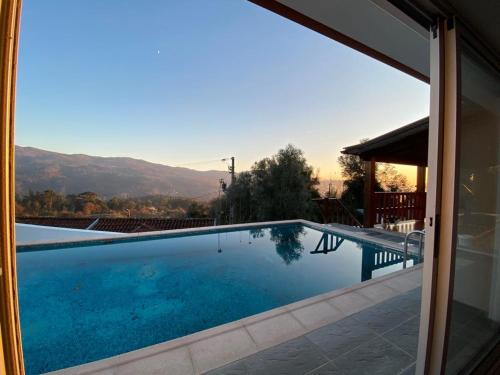 a swimming pool seen through a sliding glass door at Gondoriz-House in Terras de Bouro