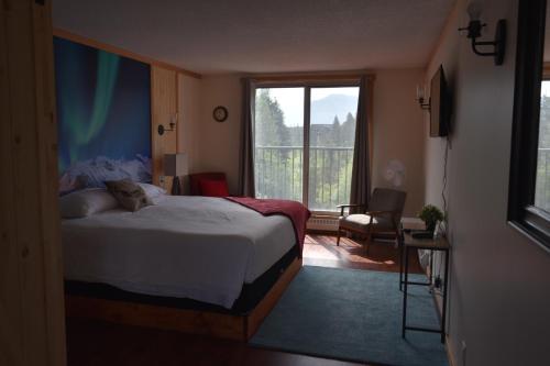 a bedroom with a bed and a large window at The Drake Inn in Canmore