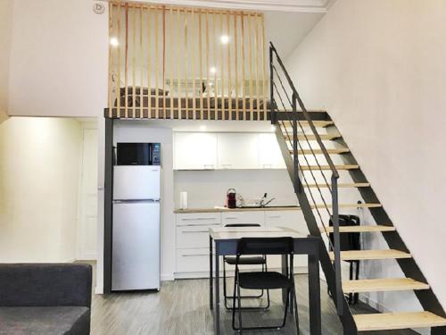 une cuisine avec un escalier menant à un loft dans l'établissement Lodge Nicolas, Hyper Centre, à Nantes