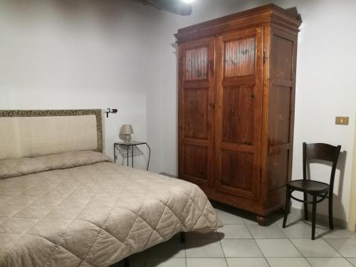ein Schlafzimmer mit einem großen Holzschrank und einem Bett in der Unterkunft CASA SERENA UNO - CENTRO STORICO in Montepulciano