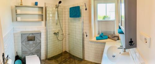uma casa de banho com um chuveiro e um lavatório. em Sunny Corner Holiday Apartment em Rheinböllen