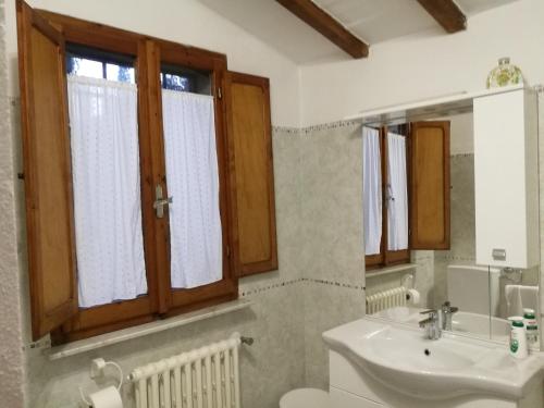 ein Bad mit einem Waschbecken, einem WC und Fenstern in der Unterkunft CASA SERENA UNO - CENTRO STORICO in Montepulciano