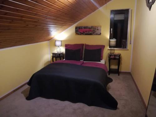 um quarto com uma cama grande e um tecto em madeira em casa Martinez em Rollesbroich