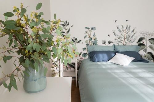 1 dormitorio con 1 cama y un jarrón de flores en Le cocon de Jules en Colmar