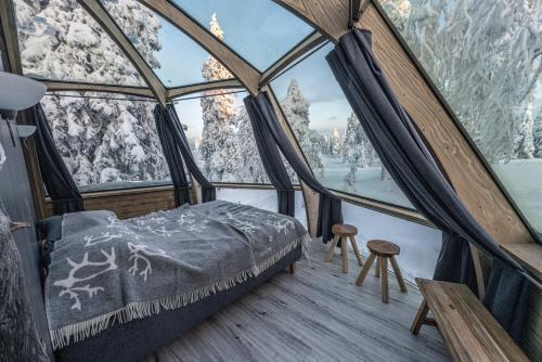 a room with a bed in a igloo with snow covered mountains at Syöte Igloos in Syöte