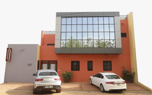 two cars parked in front of a building at Villa Mariam in Bamako