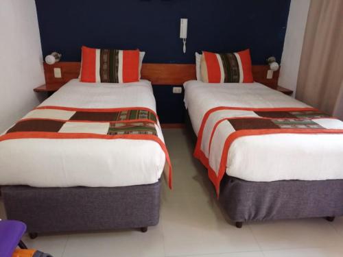 two beds in a hotel room with at Hotel Esmeralda in Iquique