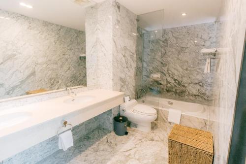 a bathroom with a sink and a toilet and a tub at Blue Arch - Luxury Serviced Apartment in Central Saigon in Ho Chi Minh City