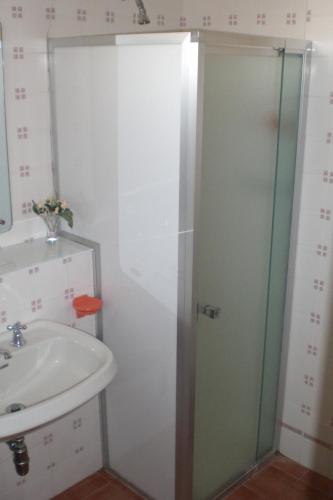 a bathroom with a glass shower door next to a sink at Hotel La Meridiana in Brisighella