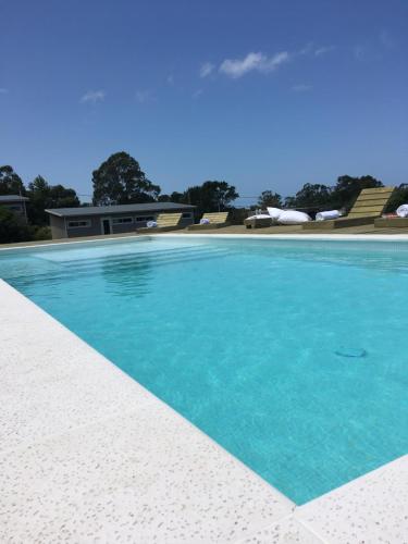 a large swimming pool with blue water at Hjem Studios in La Pedrera
