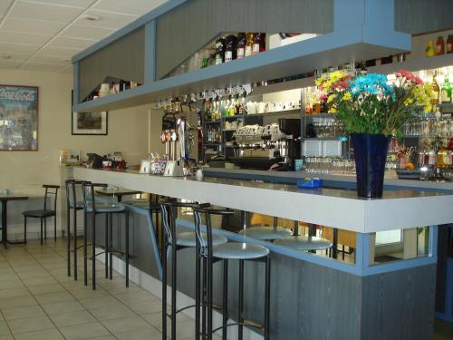 a bar in a restaurant with stools at ALIOS Hôtel Restaurant in Bas-Mauco