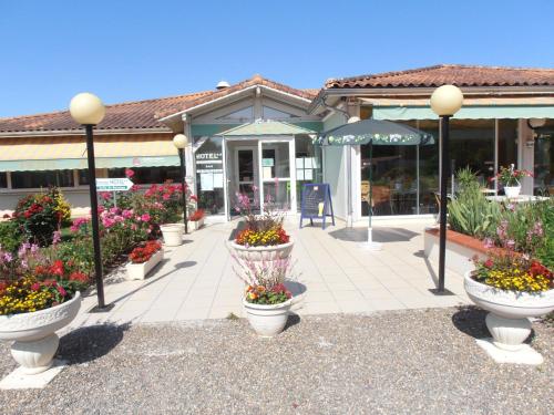 a group of flower pots in front of a store at ALIOS Hôtel Restaurant in Bas-Mauco