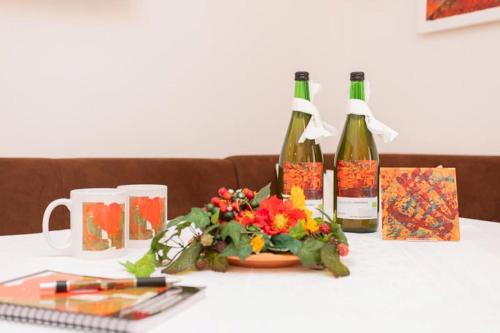a table with two bottles of wine and flowers at Appartementhaus Casamarai in Saalbach Hinterglemm