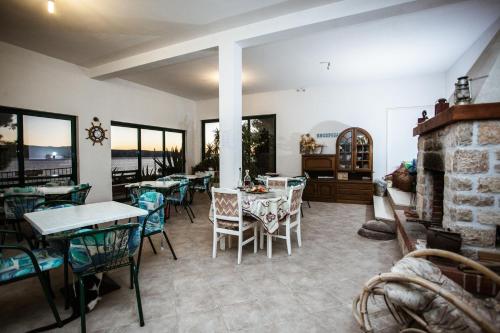 a dining room with tables and chairs and a fireplace at Apartments Agava-Mirjana in Omiš